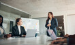 © Flamingo Images - Smiling businesswoman giving her team a whiteboard presentation in an office
