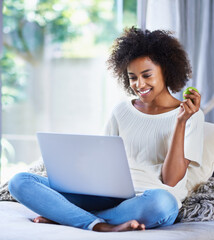 Apple, fresh produce and woman on sofa with laptop for social media, lifestyle blog and food website at home. Happy female person, technology and fruit for nutrition, healthy diet and clean eating