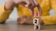 © FAMILY STOCK - Wooden cubes with numbers first, second, and third. Task priority and management concept. The order of priority in any activity. Set work priority.