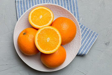 Wall Mural - Flat lay of Fresh orange fruit with sliced in plate on Colored background. Top view with copy space