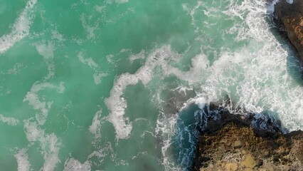 Sticker - Rocks against ocean waves, overhead super slow motion view from drone