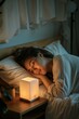 a woman sleeping in her bed with a little nightlight on