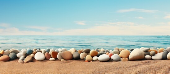 Poster - Tranquil Shoreline Scattered with Numerous Boulders under the Clear Blue Sky