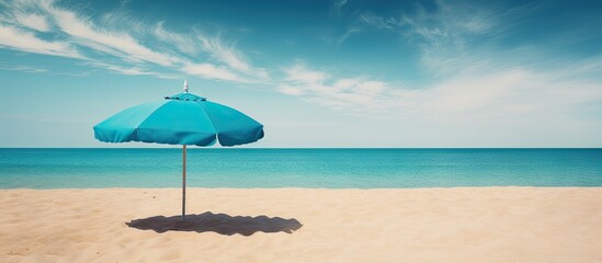 Aufkleber - Tranquil Beach Scene: Blue Umbrella Providing Calm Respite on Sun-Drenched Coastline
