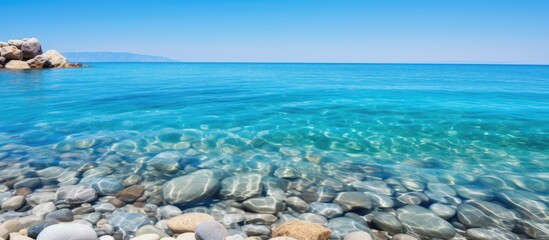 Poster - Tranquil Seashore: Clear Blue Ocean Dotted with Stones under Sunny Sky in Summer Resort City