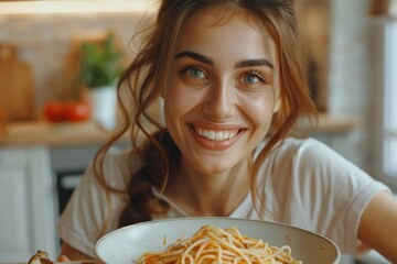 Close-up of charming young Caucasian girl eating delicious homemade Italian spaghetti, looking at camera. Happy smiling European lady enjoying tasty lunch, sitting in cozy kitchen. World Pasta Day.