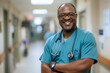 © JR-50 - High resolution portrait of a compassionate doctor in scrubs stethoscope around the neck confident smile standing in a well lit hospital corridor