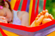 Young beautiful girl sleeping in a hammock with bare feet, relaxing and enjoying a lovely sunny summer day. Safety and happy childhood and leisure concept. Selective focus