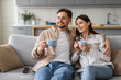 © Prostock-studio - Spouses with coffee cups enjoying time on sofa