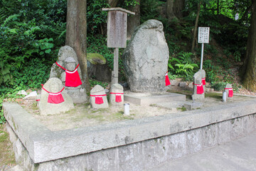 traditional japanese jizo statues adorned with red bibs at a kiyomizudera temple