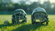 Two cricket batting helmets with protective grills positioned on the vibrant green surface of a cricket ground