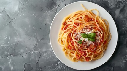 Wall Mural - Top view of Spaghetti Bolognese in a white plate on black slate background with copy space. Italian pasta with minced beef sauce, tomatoes, parmesan cheese and fresh basil. Classic Italian cuisine.