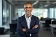 © FutureStock - Portrait of a smiling mature businessman with arms folded at office.