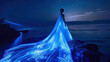 Bride in glowing blue dress on sea shore at night