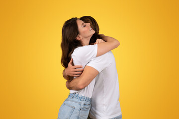Wall Mural - An intimate moment as a woman with long brown hair hugs a man from behind