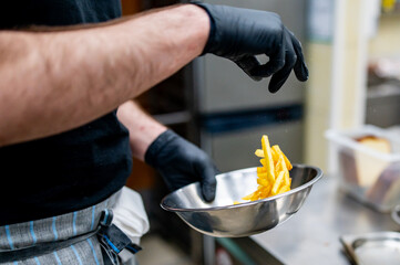 Wall Mural - chef preparing french fries in restaurant kitchen