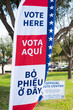 Political vote flag in multiple language English, Spanish, Vietnamese shows Vote Here text, polyester double-sided election decorations polling locations rotating spike base, Dallas, TX