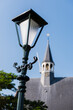 Close up of a classic standing street light in the village Oudenhoorn in the Netherlands. The reformed protestant church is in the background.