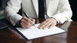 © Sun - Corporate Agreement: Businessman and Businesswoman Signing Important Contract at Office Desk with Pen, Paper, and Closeup of Handwriting in a Professional Meeting Setting