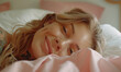 European woman lying in bed, just woken up, looking sleepily at the camera