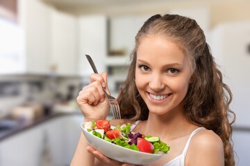 Happy young lady eating homemade dish