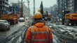 © tonstock - An engineer examines a construction report on site, with the expressway project and machinery visible behind him.