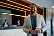 © Drazen - Happy black man in hotel looking at camera.