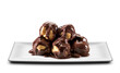 white rectangular plate with profiteroles, cream puffs covered in chocolate