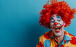 A clown with red hair and a red wig is smiling and looking at the camera. the clown is dressed in a bright and colorful outfit.funny man clown, April Fool, circus performer, wide smile and laughter