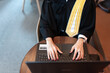 Top view of Asian female lawyer's hand working Typing with a laptop, wearing a legal suit, representing clients and defendants online while waiting to mediate. Submit a complaint to the prosecutor