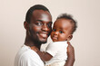 © olga - Happiness Of Fatherhood. Portrait of young black dad with cute little baby on his hands.Loving african american father spending time with infant child, copy space.