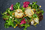 Fototapeta Desenie - vegetarian, appetizer, pears with gorgonzola au gratin on salad and sliced, roasted almonds on a slate plate