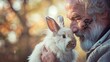 An imposing man with a scarred face gently brushing and caring for a fluffy angora rabbit