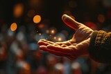 Fototapeta  - Close up of a hand performing a magic trick, with a blurred audience in the background to add intrigue.