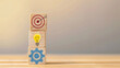 © Maciej Koba - Stacked Wooden Blocks with Icons of a Target, Light Bulb, and Gear on Gradient Background
