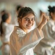Karate or Judo asian martial art training in a dojo hall. Young student teenager wearing white kimono smiling, looking at camera learning fighting, students lesson on room on background 
