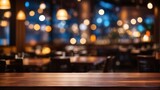 Fototapeta Sport - Empty dark wooden table in front of abstract blurred restaurant background