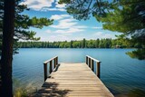 Fototapeta Pomosty - A serene dock on a lake with trees in the background. Perfect for nature-themed designs