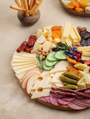 Wall Mural - Cheese plate with different types of cheese, fruits, nuts on a light background