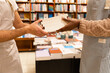 © ADDICTIVE STOCK - Handover of books at bookstore checkout