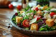 Fresh salad with croutons and tomatoes on wooden table, closeup. Caesar salad with copy space.