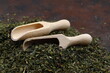Green  tea with herbs in wooden spoons on a wooden board