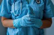 A healthcare professional in scrubs and gloves carefully examines a finger