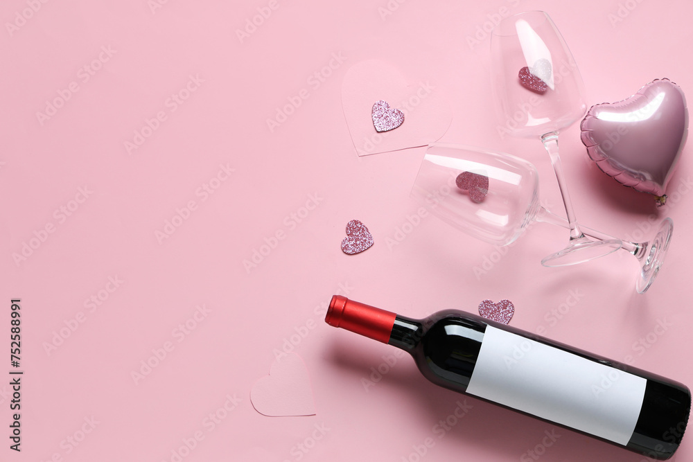 Bottle of wine with glasses and decor on pink background. Valentine's Day celebration