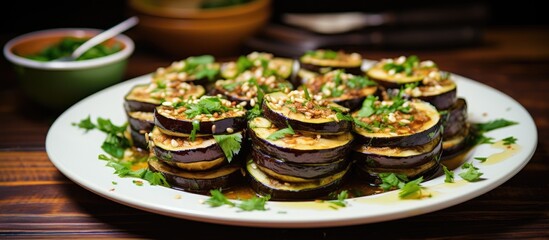 A white plate is topped with sliced eggplant, baked to perfection and garnished with fresh parsley leaves. The dish offers a healthy and tasty vegan meal option for summer.