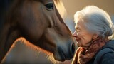 Fototapeta  - Elderly woman and horse sharing gentle nose-to-nose touch. Concept of animal therapy, companionship, elderly care, leisure and nature bonding.