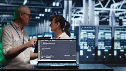 Cloud computing business executives solving tasks in data center, running scripts on laptop terminal. Knowledgeable IT team amidst servers, accessing databases and manipulating lines of code