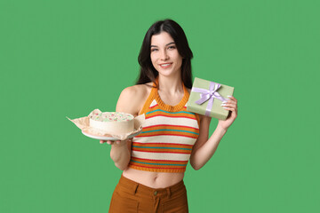 Poster - Beautiful young woman with sweet bento cake and gift box on green background. International Women's Day