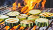 Zucchini slices cooking over flaming grill.