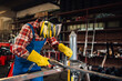 © Zamrznuti tonovi - Man holding a metal plate upright as he prepares to weld it precisely.